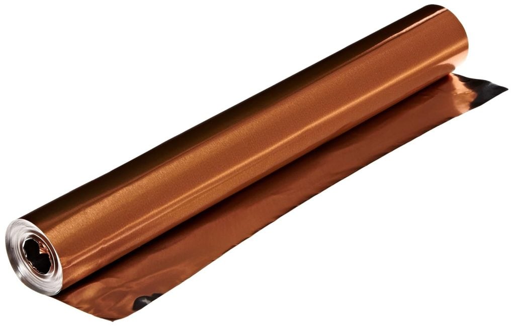 A roll of shiny copper-colored foil, perfect for crafting wreaths for fall, partially unrolled on a white background.