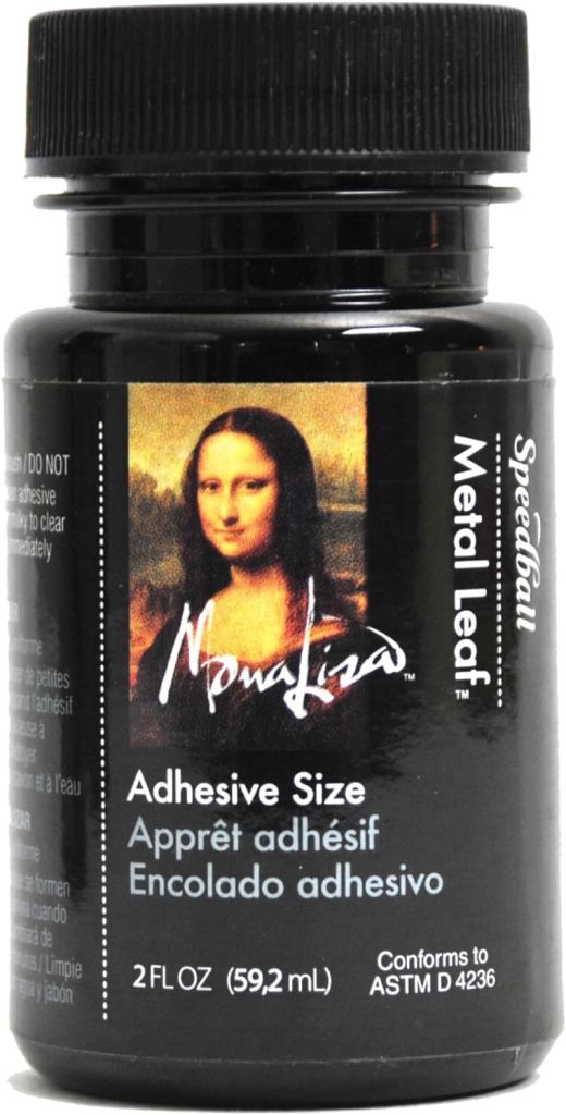 A 2 fluid ounce bottle of Mona Lisa adhesive size for metal leaf, labeled in English, French, and Spanish. The black packaging features an image of the Mona Lisa painting adorned with fall pumpkin motifs.