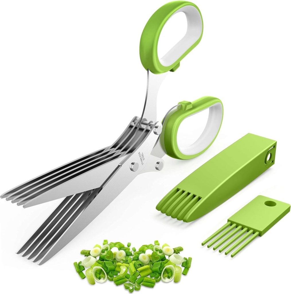 Green-handled herb scissors with five blades, a cleaning comb, protective cover, and chopped green onions—perfect for topping a fresh protein bowl—displayed on a white background.