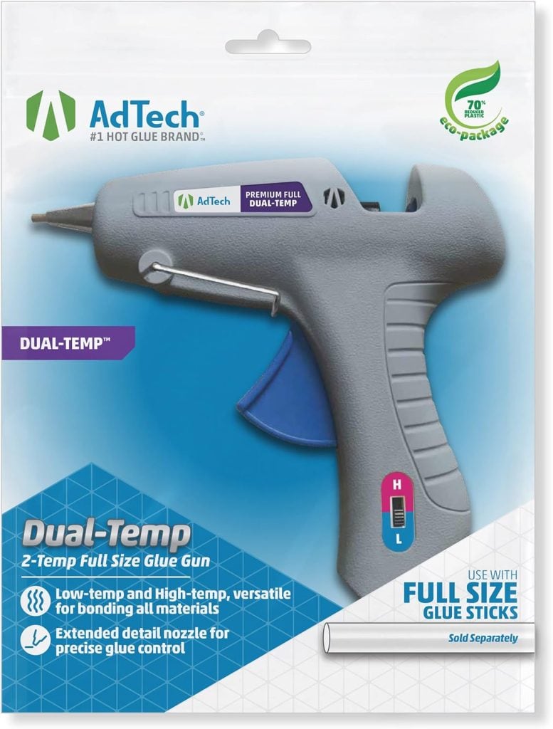 The image shows the packaging for an AdTech Dual-Temp 2-Temp Full Size Glue Gun. It highlights features like low and high temp settings, perfect for creating wreaths for fall, and an extended detail nozzle, all packaged in an eco-friendly box.