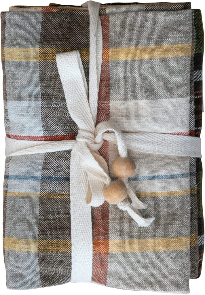 A folded, multicolored striped cloth bundle tied with a white ribbon and two wooden beads—perfect for storing kitchen essentials or adding a touch of charm to your pantry cabinet ideas.