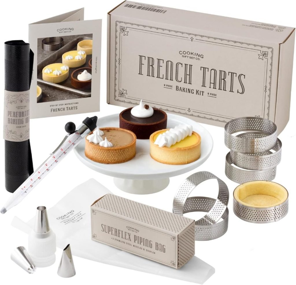 French tarts baking kit, featuring molds, a piping bag, thermometer, and a recipe booklet for delightful creations like pear and cranberry tart, all beautifully displayed on a white background.