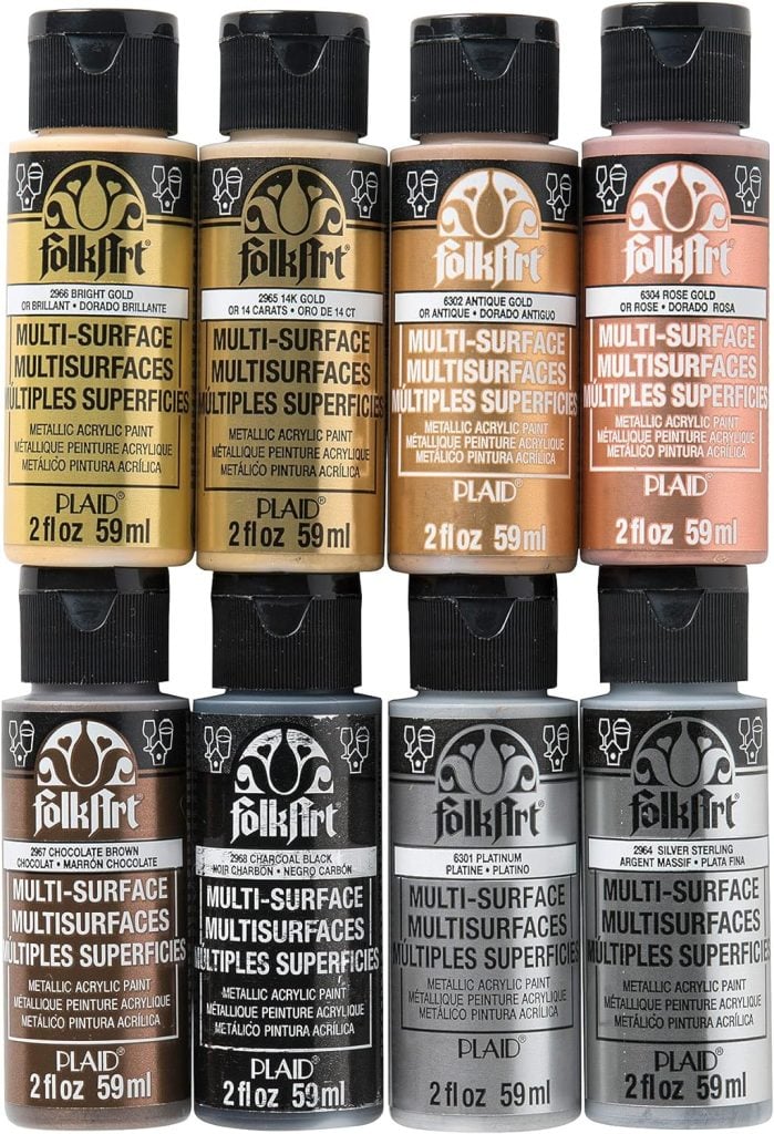 A set of nine 2 fl oz FolkArt multi-surface acrylic paint bottles, arranged in a 3x3 grid, featuring various shades of metallic gold and copper—perfect for crafting wreaths for fall.