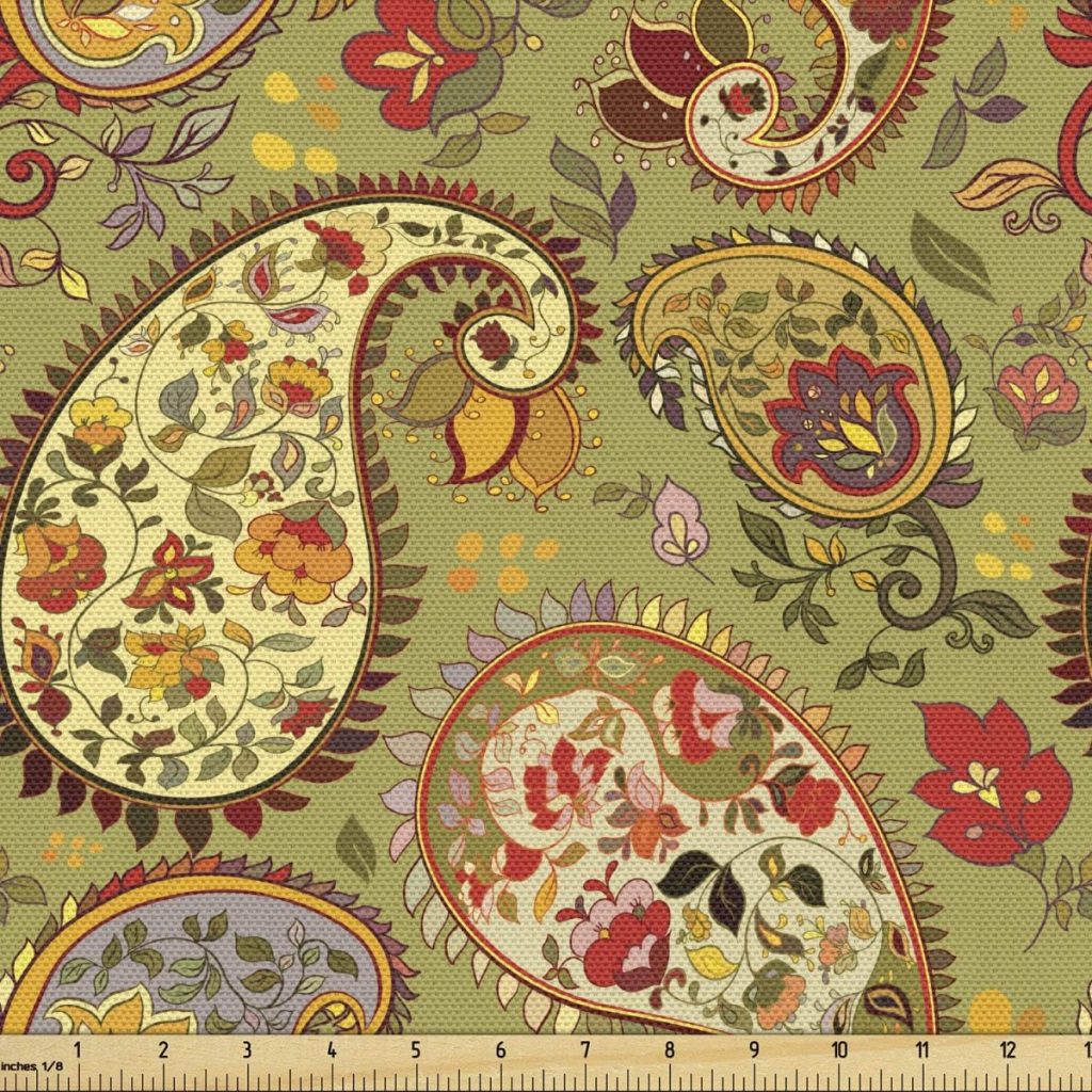 A patterned fabric with a paisley design featuring various flowers, fall pumpkins, and leaves in shades of red, purple, yellow, and green on a khaki background, with a measurement scale at the bottom.