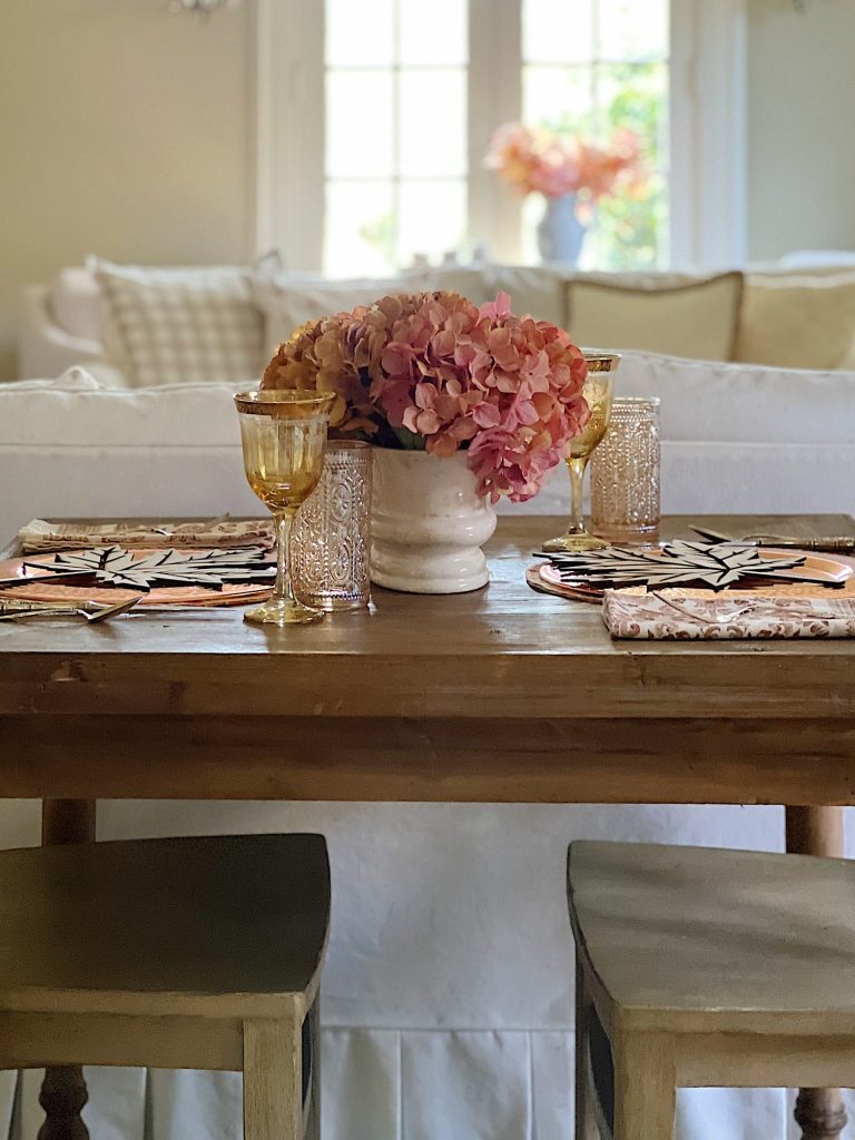 A fall themed table with a placemat, copper charger, amber glassware and a fall leaf wood charger cut with a laser cutting machine.