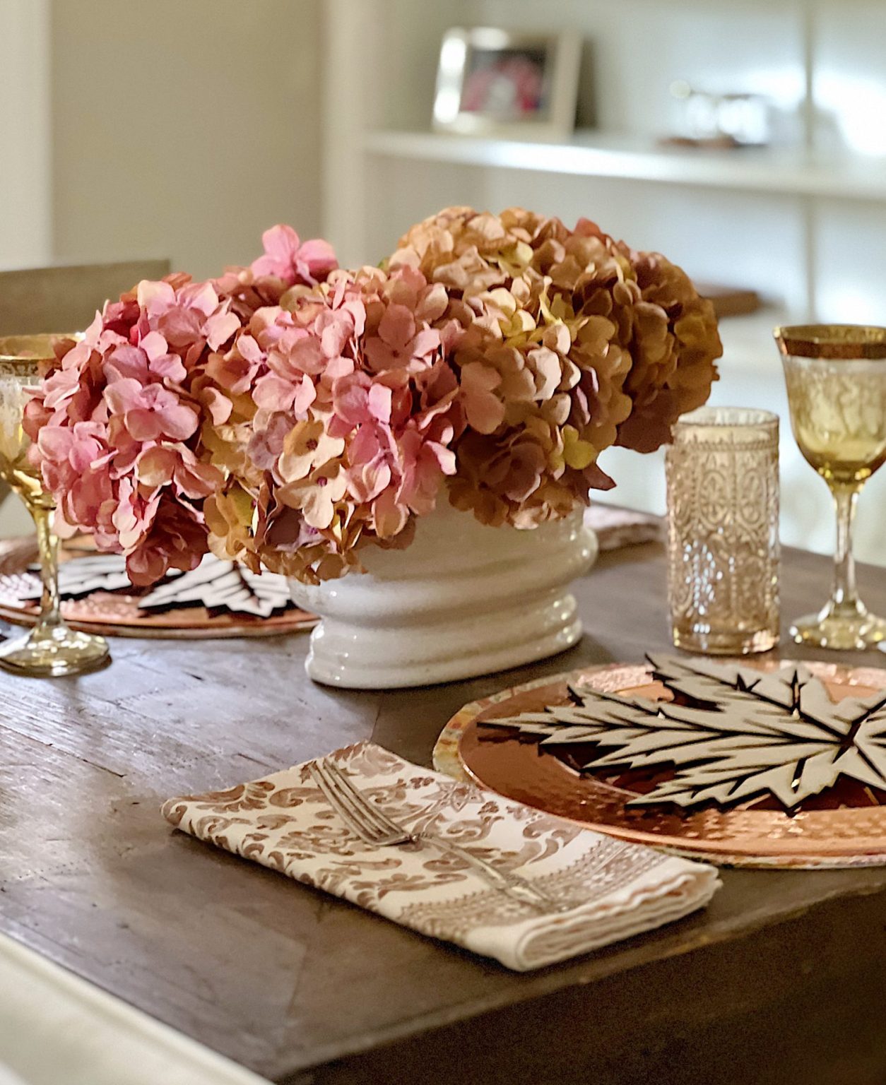 A fall themed table with a placemat, copper charger, amber glassware and a fall leaf wood charger cut with a laser cutting machine.