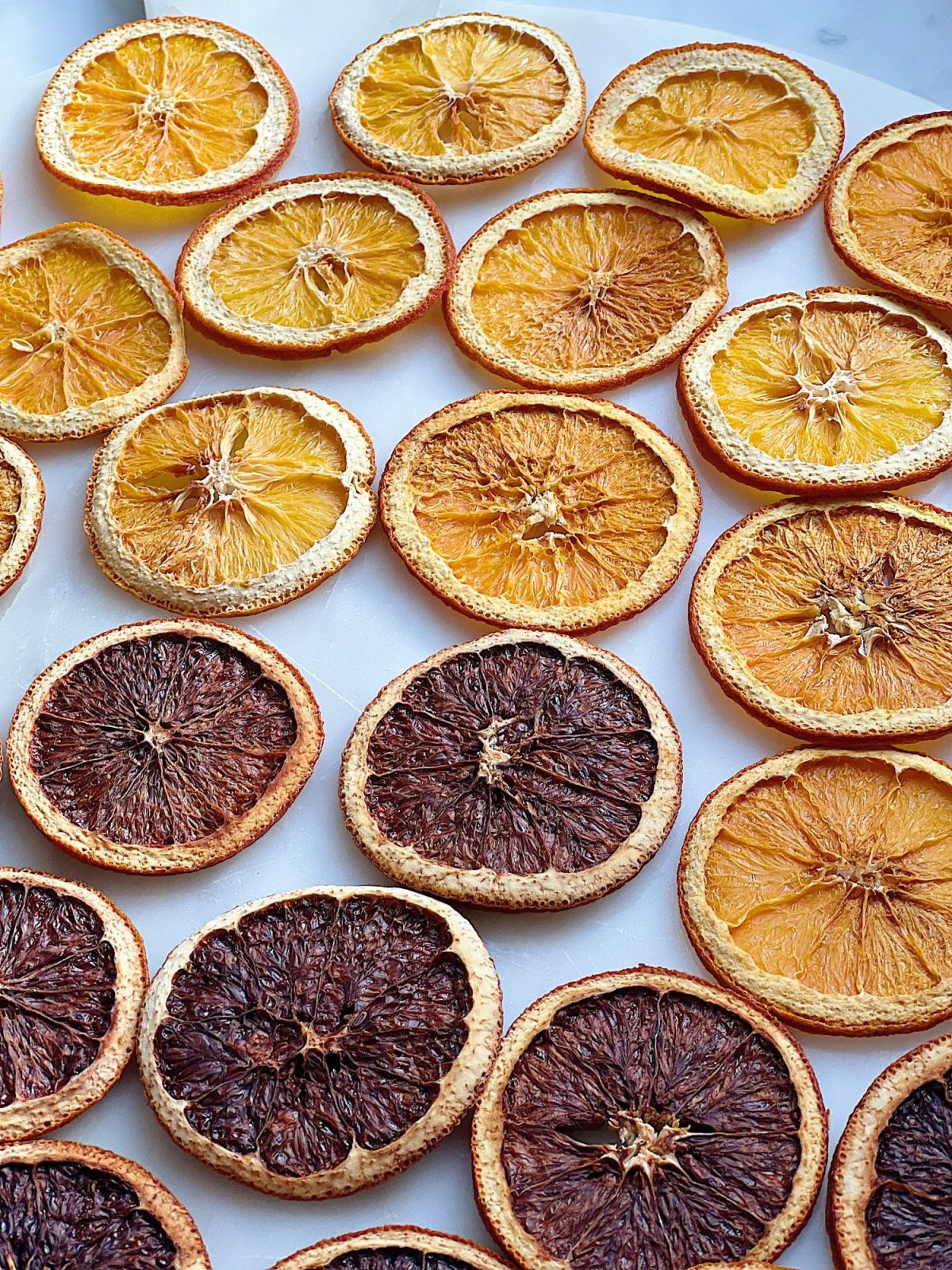 A DIY Halloween wreath made with a eucalyptus wreath and dried orange slices.