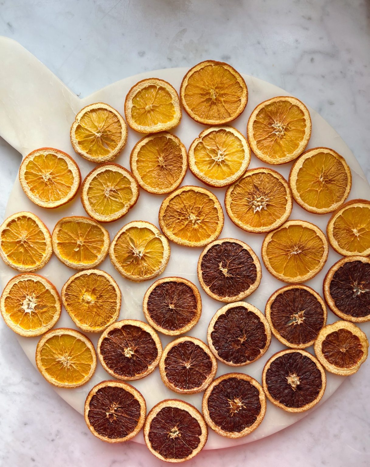 A DIY Halloween wreath made with a eucalyptus wreath and dried orange slices.