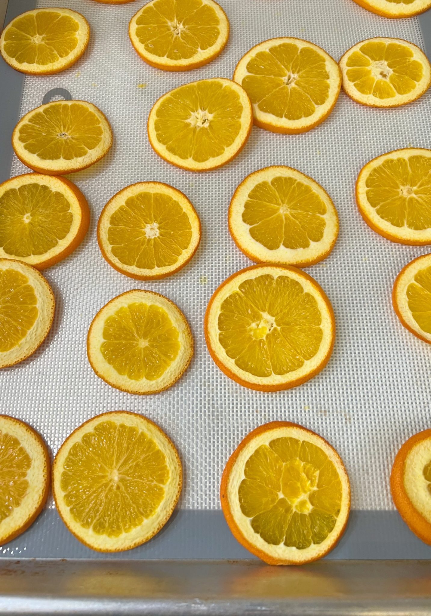 A DIY Halloween wreath made with a eucalyptus wreath and dried orange slices.