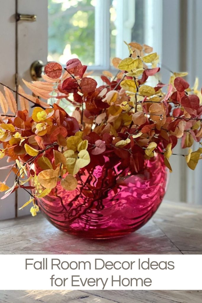 A vintage cranberry bowl with faux flowers decorate for fall.
