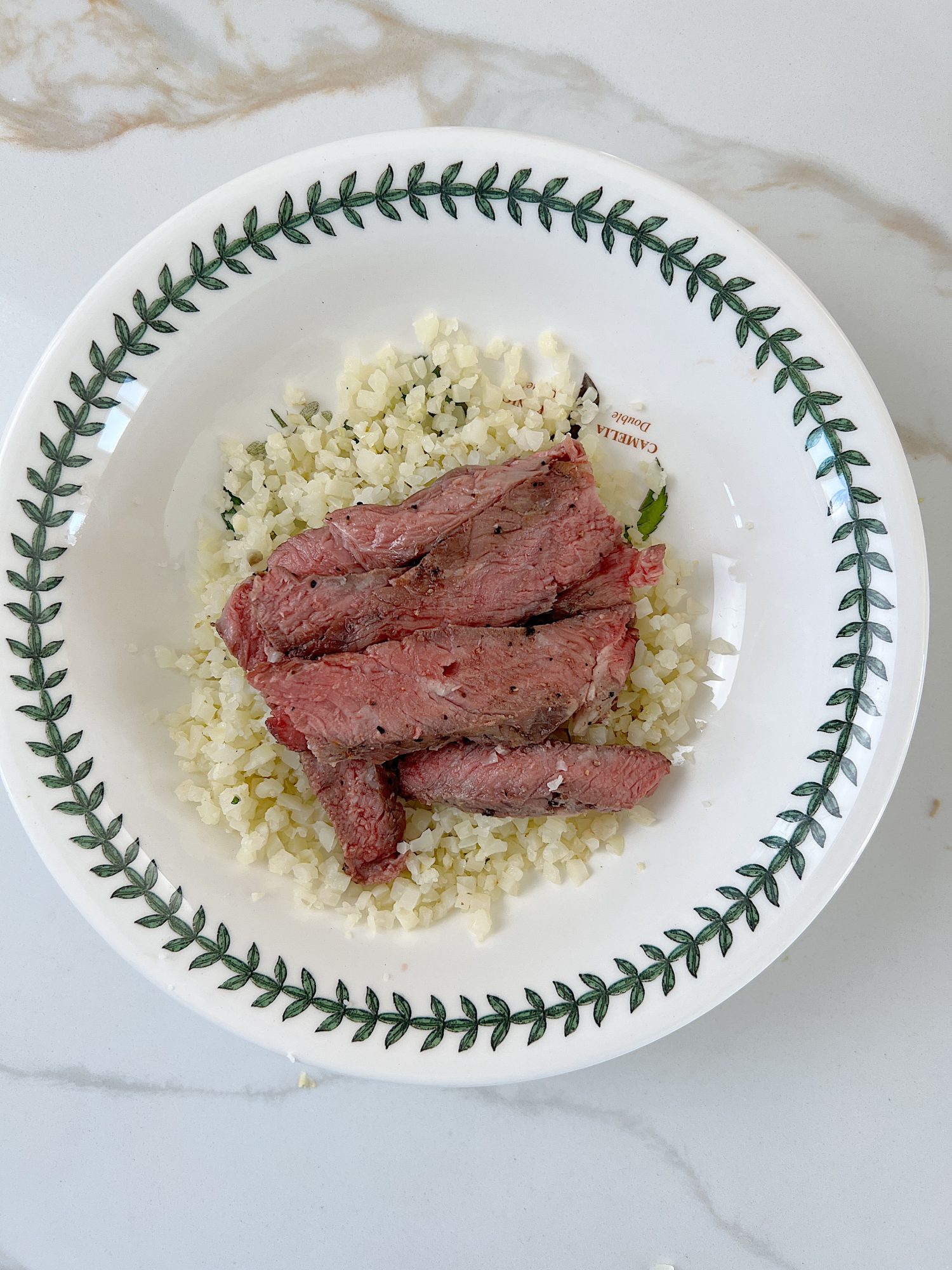 The best beef protein bowl with cauliflower rice, sauted onions and tomatoes, avocado, and fresh cilantro.