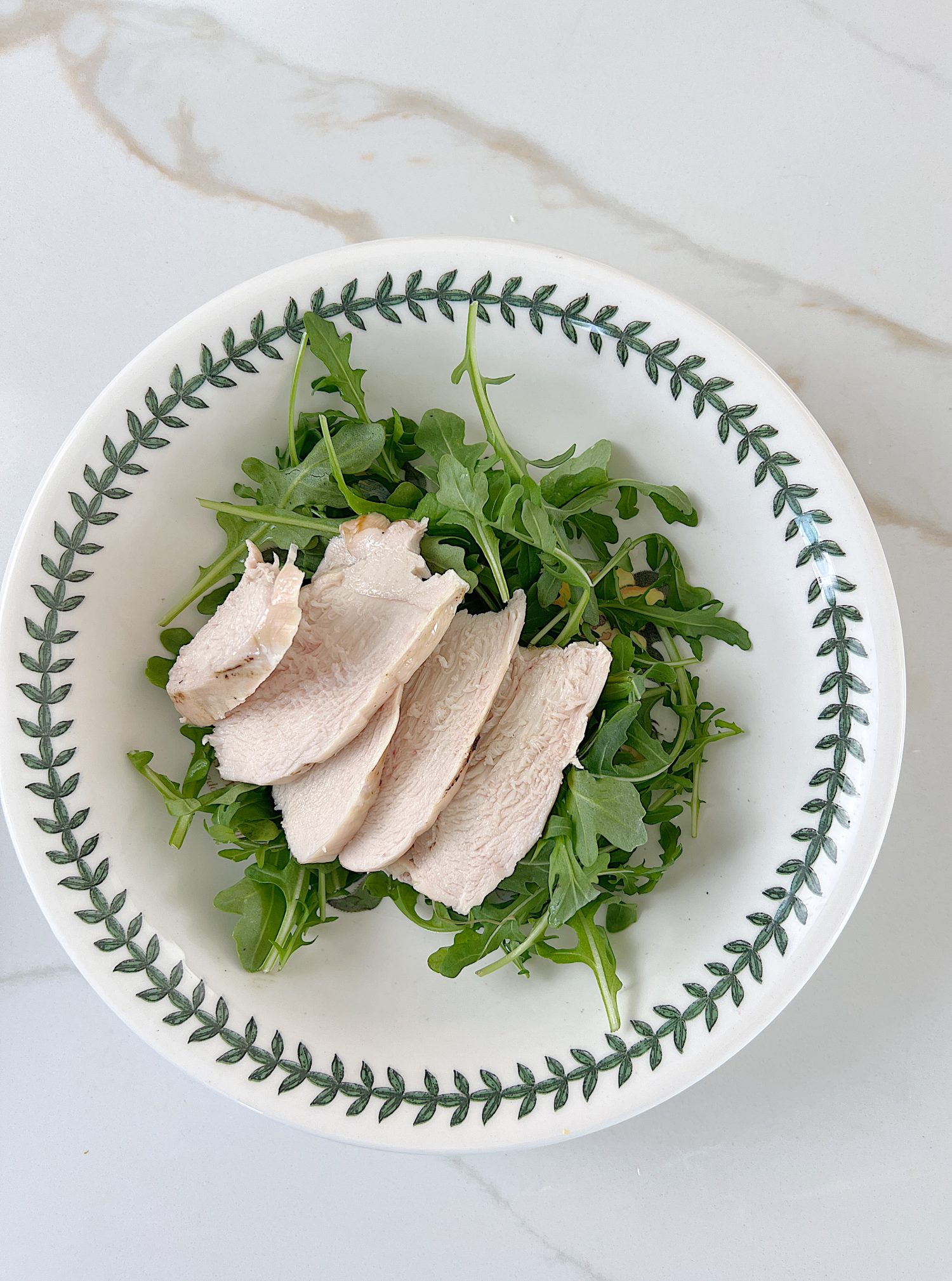 The best chicken protein bowl with arugula, tomatoes, cucumbers, avocado, and gorgonzola.