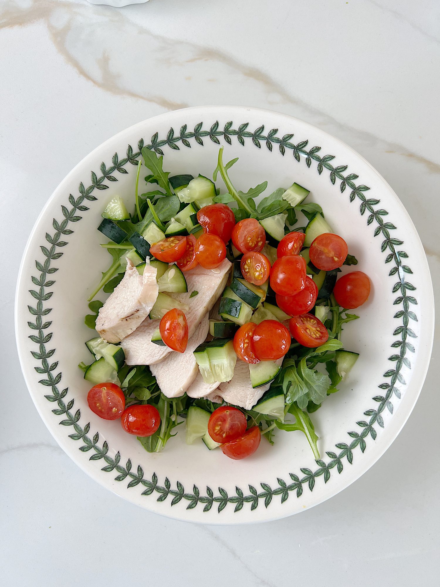 The best chicken protein bowl with arugula, tomatoes, cucumbers, avocado, and gorgonzola.
