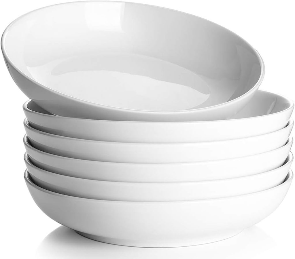 A stack of six white ceramic bowls, perfect for showcasing fall soup recipes, with one bowl placed slightly askew on top.