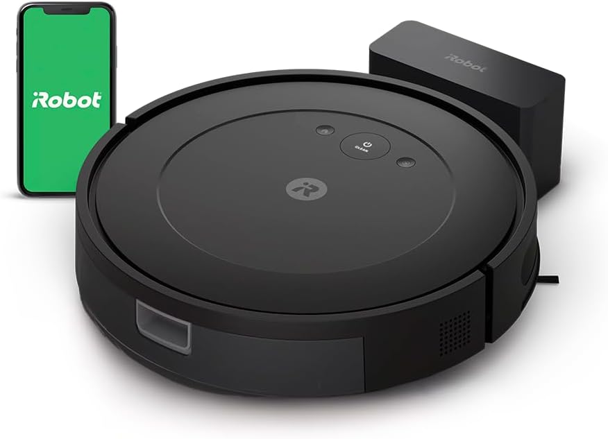 Image of a black iRobot Roomba vacuum cleaner with a charging station and a smartphone displaying the iRobot app, perfect for cleaning up after baking Halloween sugar cookies.