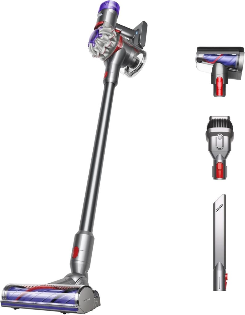 A cordless stick vacuum cleaner with a purple and grey design, reminiscent of Halloween sugar cookies, accompanied by three interchangeable attachments for different cleaning tasks.