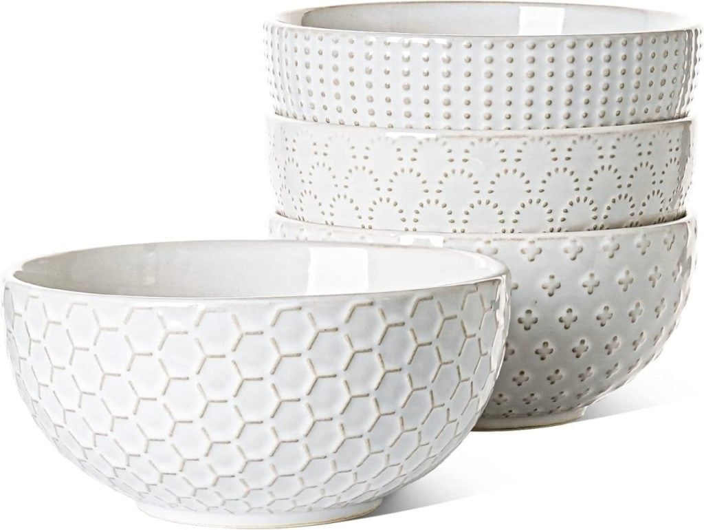 Four white ceramic bowls stacked together, each with a different textured pattern, are perfect for serving your favorite fall soup recipes.