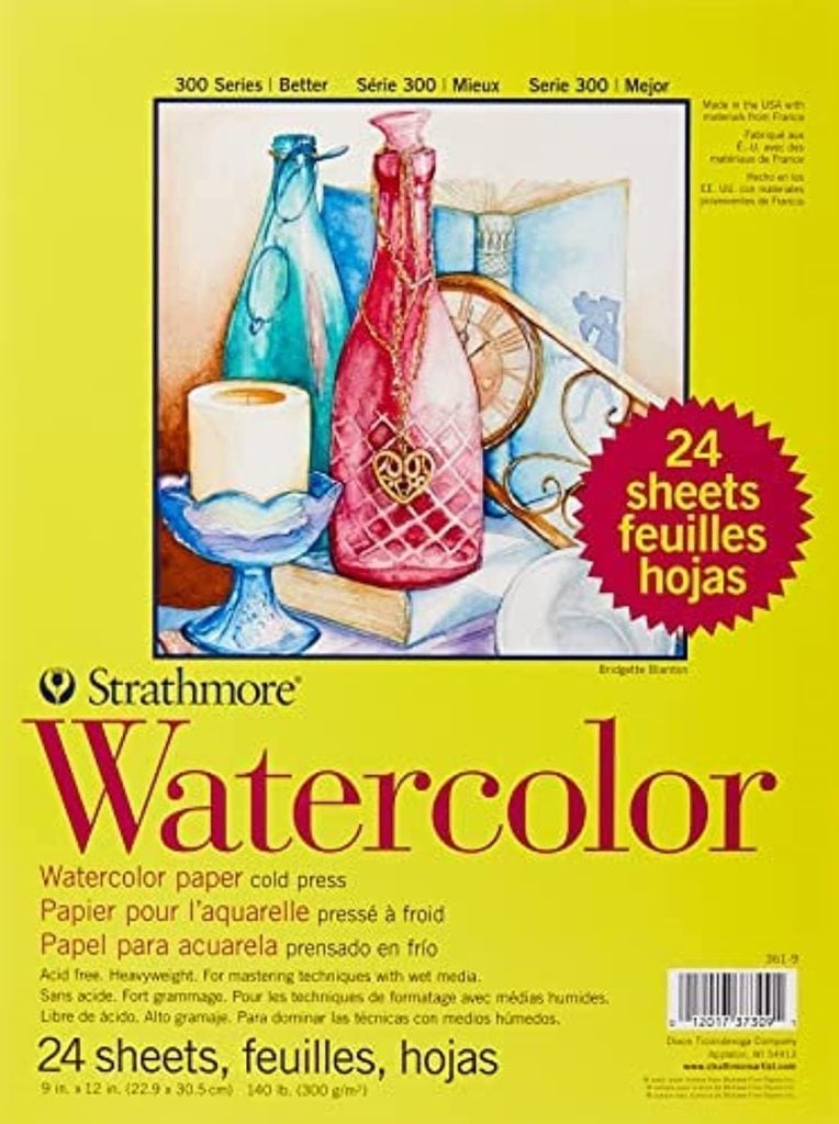 Pack of Strathmore Watercolor paper, 24 cold press sheets, featuring an art print of a bottle and apple. This yellow-covered set is perfect for a fall craft idea and provides product details in English, French, and Spanish.