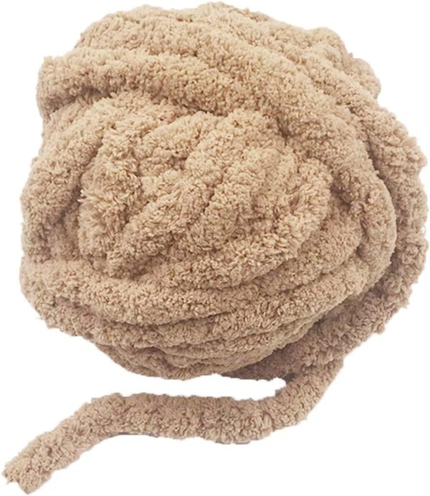 A large ball of beige, fluffy yarn, perfect for crafting a cozy fall blanket, with a loose strand extending outward.