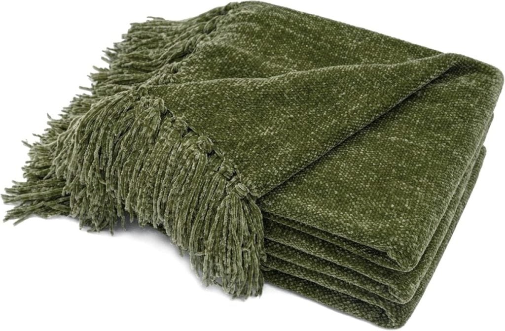 A folded green chenille fall blanket with fringed edges.