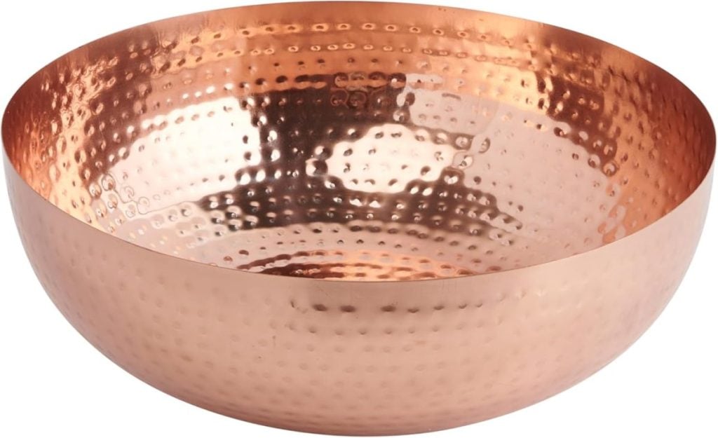 Hammered copper bowl with a shiny, textured surface that glimmers like a cozy fall blanket draped in warm, golden hues.