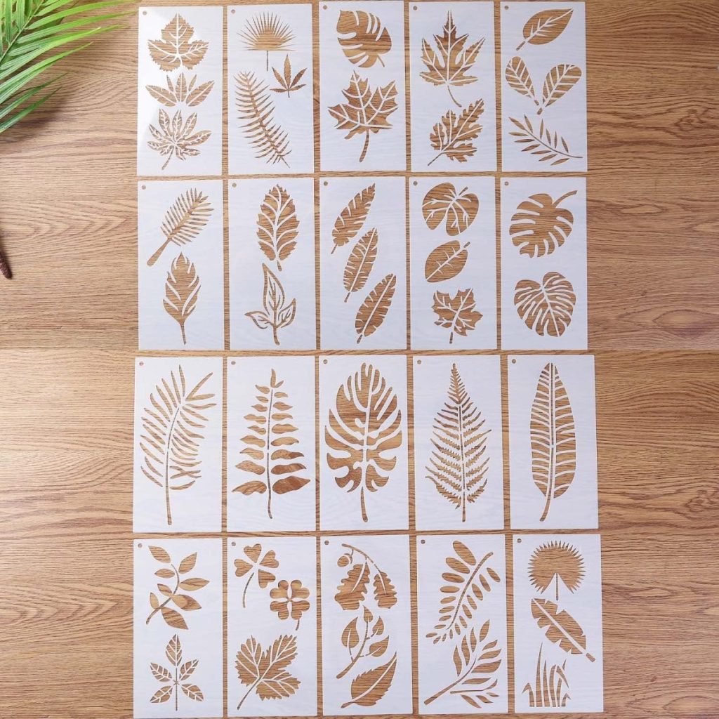 A collection of stencils featuring various leaf designs, perfect for creating cozy Fall pillows, beautifully arranged on a wooden surface.