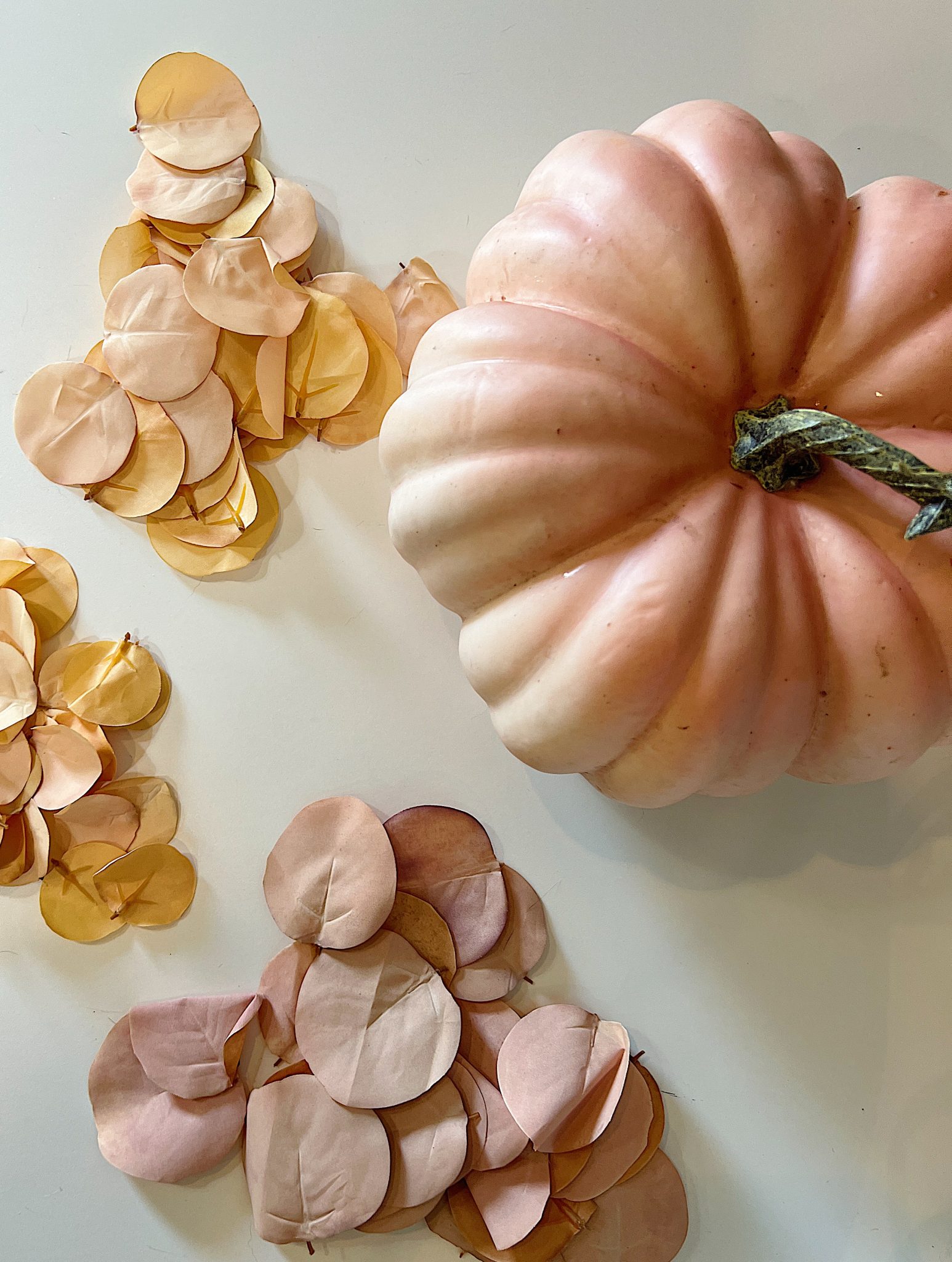 A handmade pumpkin made with a plastic cinderella pumpkin covered with faux eucalyptus leaves.
