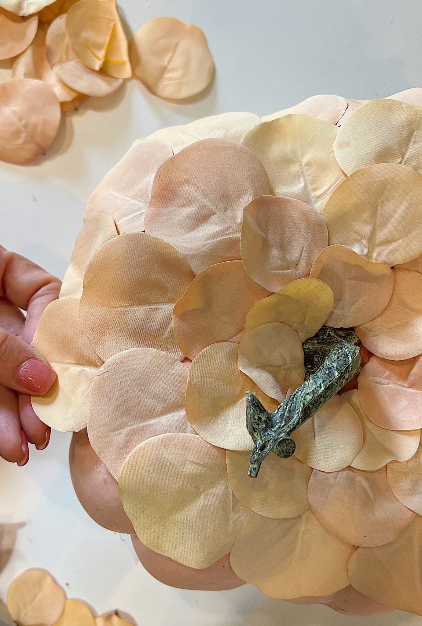 A handmade pumpkin made with a plastic cinderella pumpkin covered with faux eucalyptus leaves.