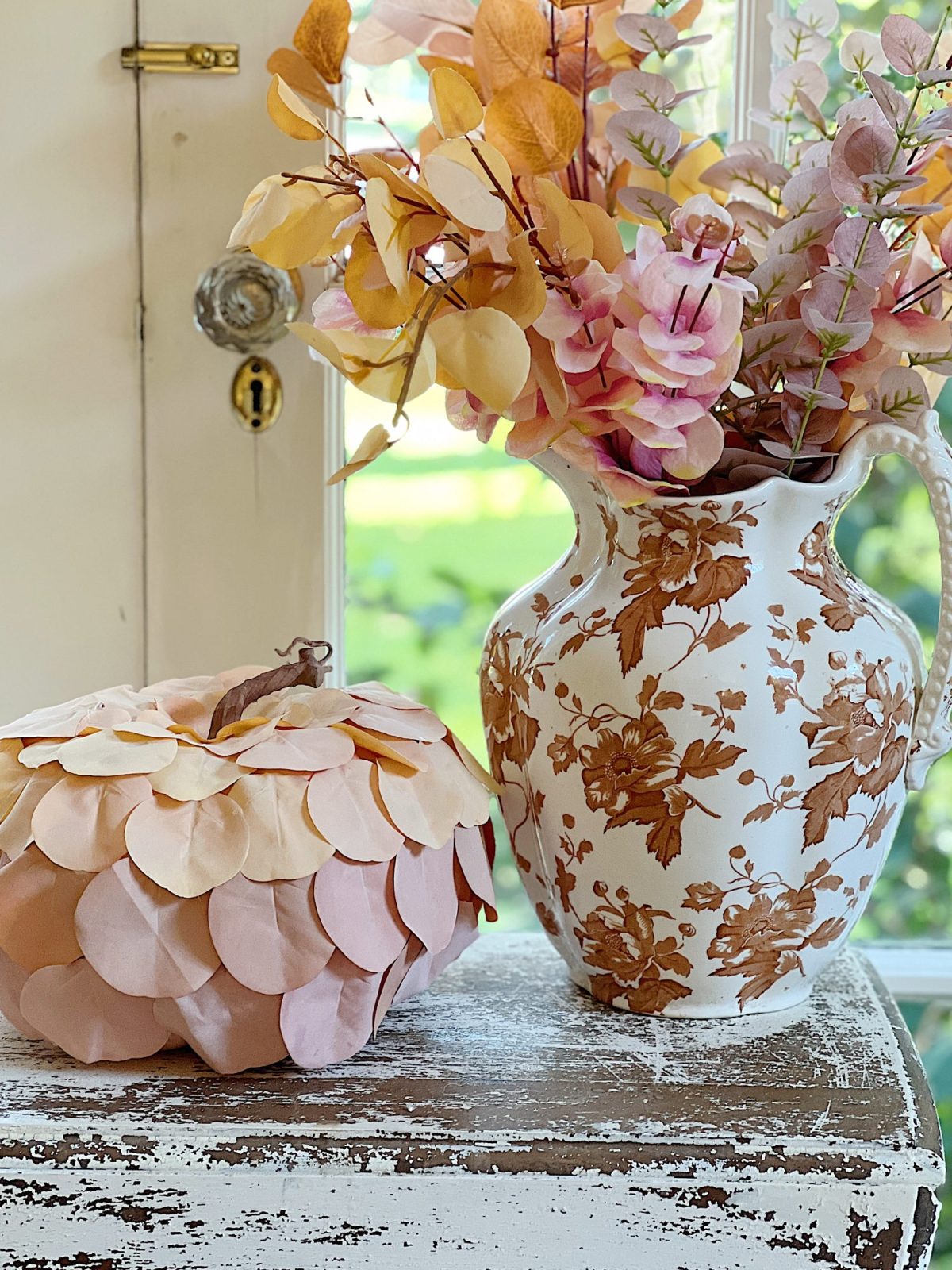 A handmade pumpkin made with a plastic cinderella pumpkin covered with faux eucalyptus leaves.