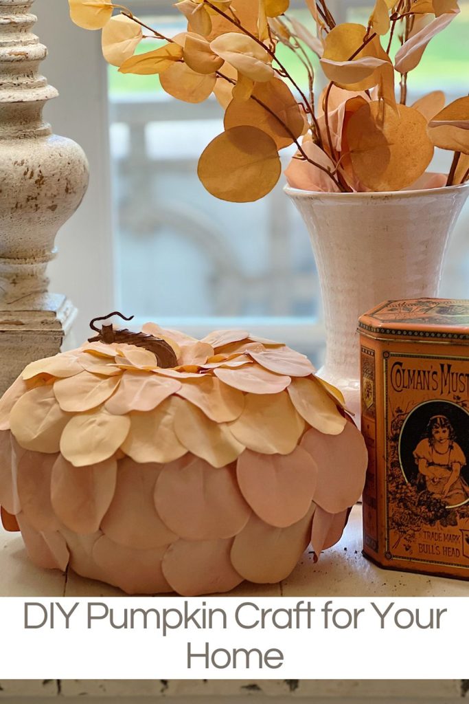 A handmade pumpkin made with a plastic cinderella pumpkin covered with faux eucalyptus leaves.