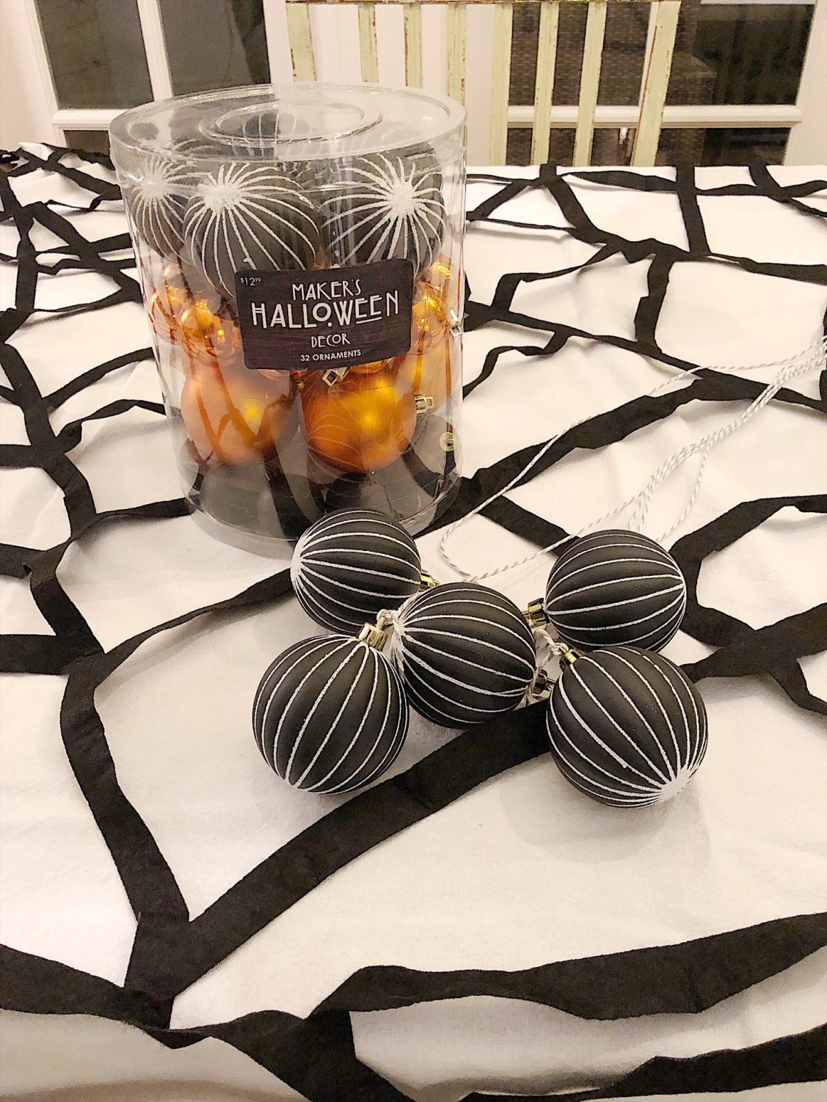 A Halloween table decorated with lights, a spider web, chalkboards, candles, cookies, candy, and more.