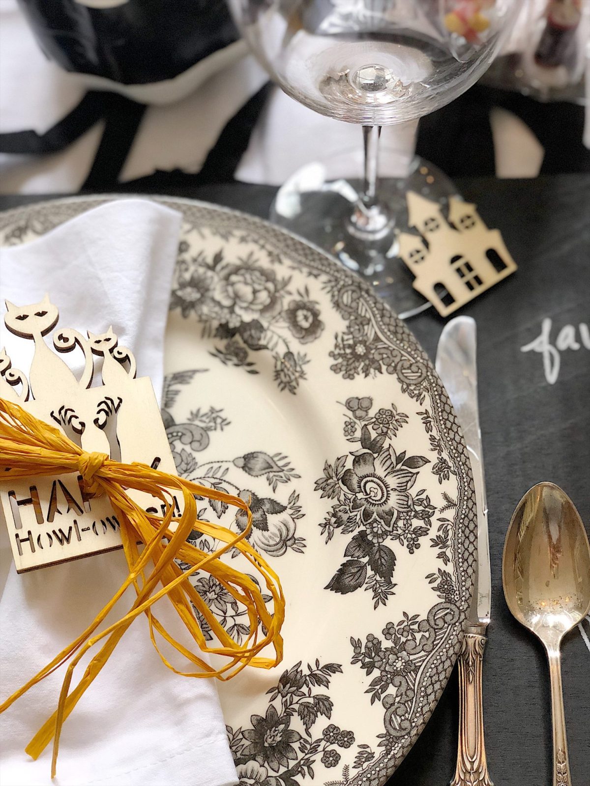 A Halloween table decorated with lights, a spider web, chalkboards, candles, cookies, candy, and more.