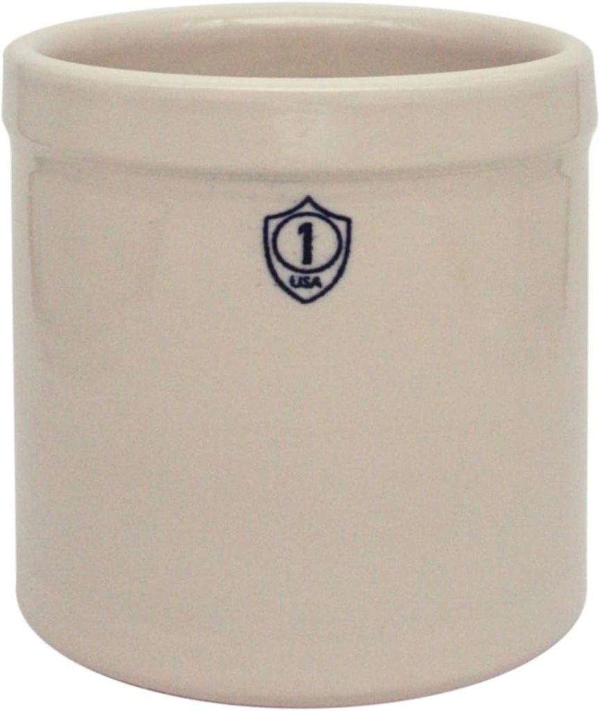 A beige cylindrical pottery crock with a blue seal reading "1 USA" on the front, perfect for storing classic Christmas cookies.