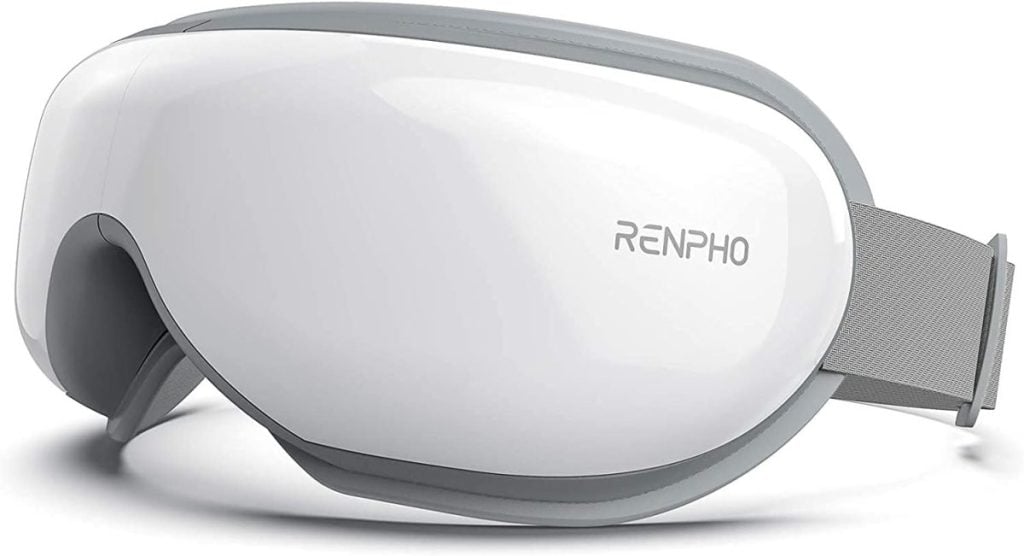 The white RENPHO eye massager, reminiscent of the serene elegance of a flocked Christmas tree, features a sleek gray trim and an adjustable strap for personalized comfort.