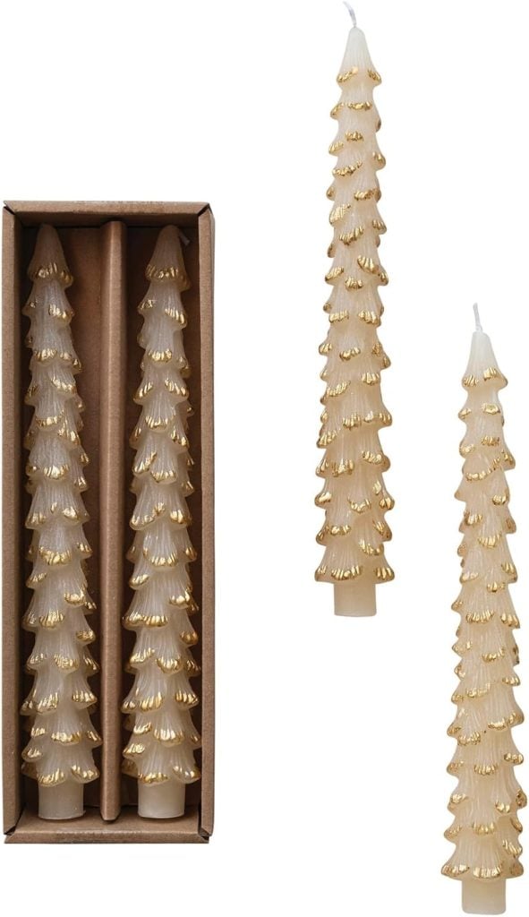 Two pine tree-shaped candles with gold accents, perfect to set a festive Christmas table, one nestled in a box and the other two standing upright.