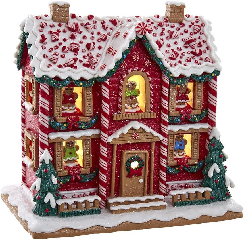 A festive Christmas gingerbread house adorned with candy canes, frosting, and wreaths, featuring illuminated windows and snow-covered trees.