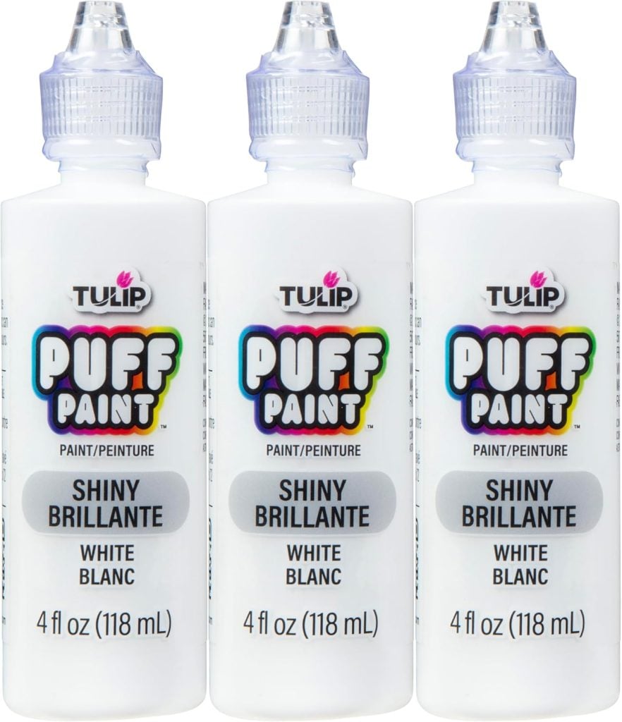 Three bottles of Tulip Puff Paint, labeled "Shiny Brillante White Blanc," perfect for adding festive details to Christmas gingerbread houses, each containing 4 fl oz (118 mL).