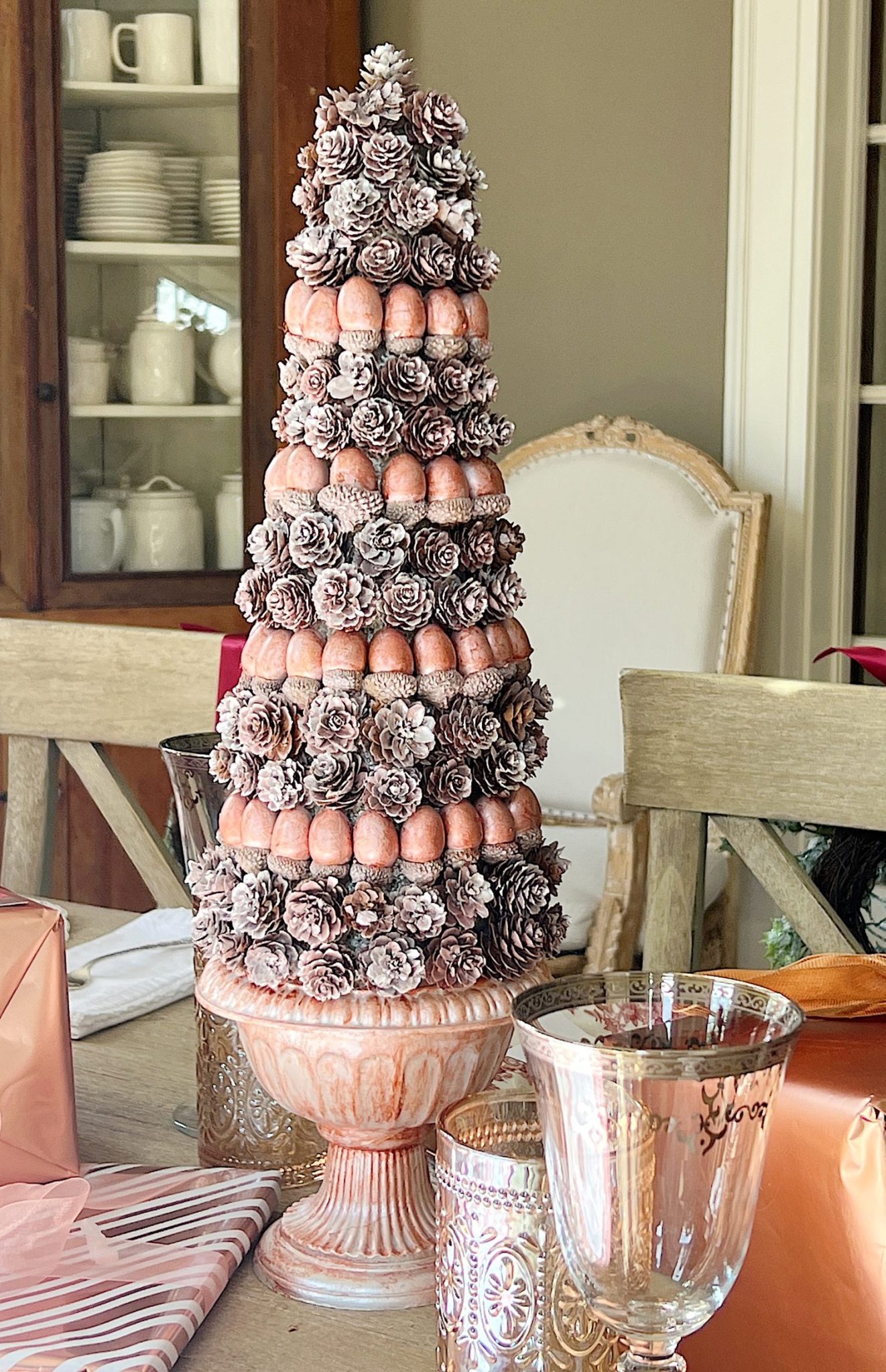 A DIY to make mini Christmas trees decorated with pinecones and acorns.
