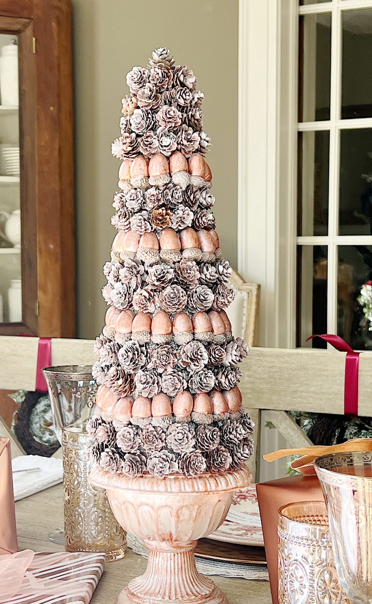 A DIY to make mini Christmas trees decorated with pinecones and acorns.