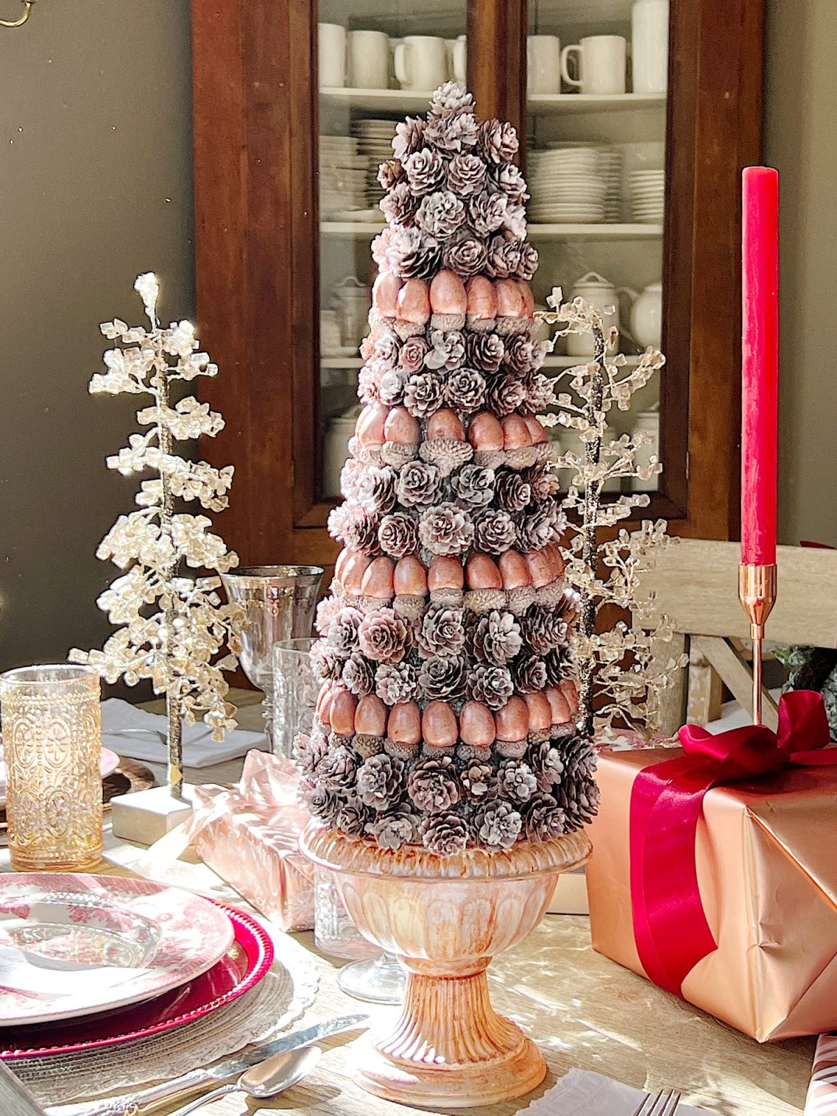 A DIY to make mini Christmas trees decorated with pinecones and acorns.