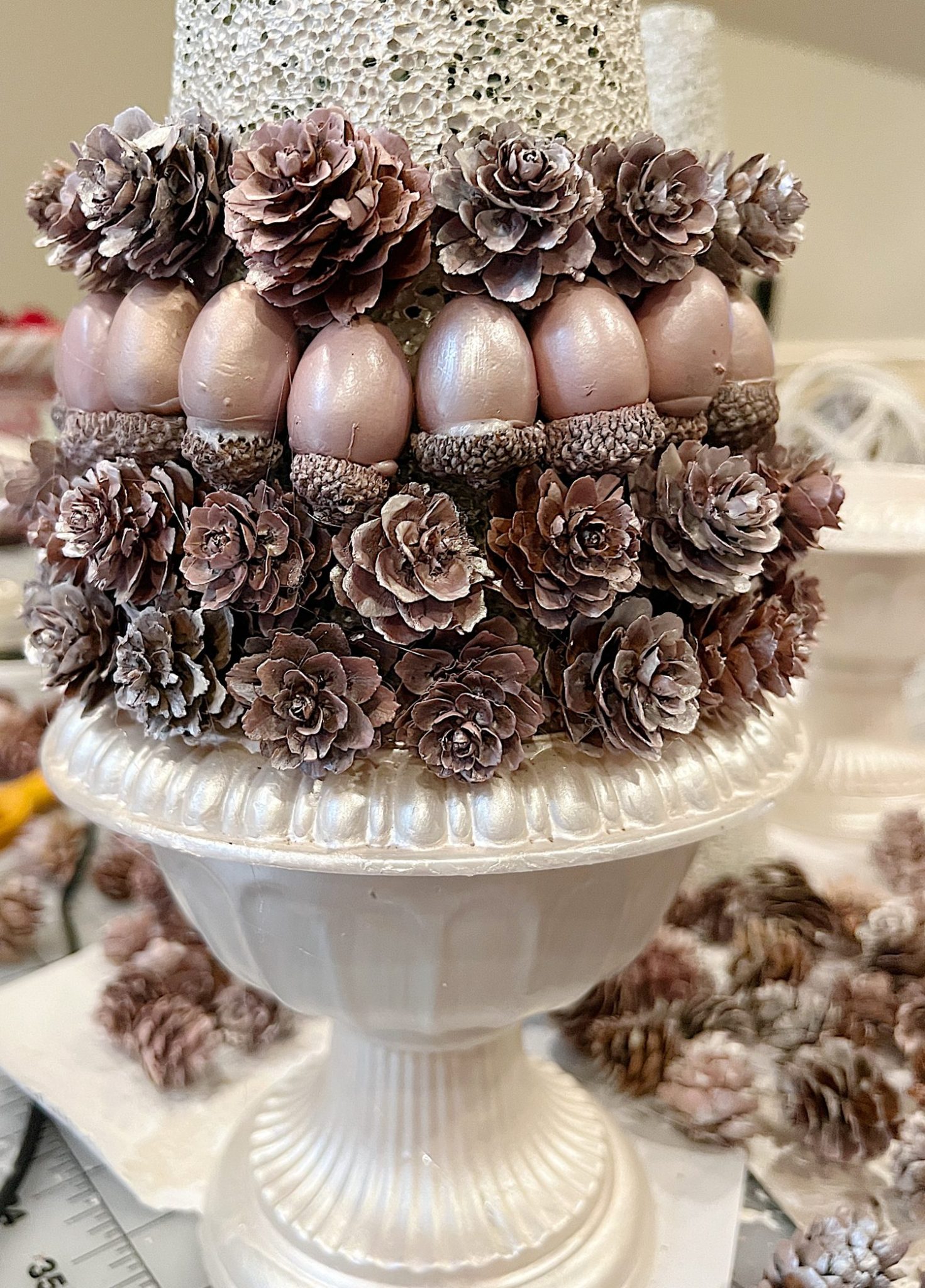 A DIY to make mini Christmas trees decorated with pinecones and acorns.