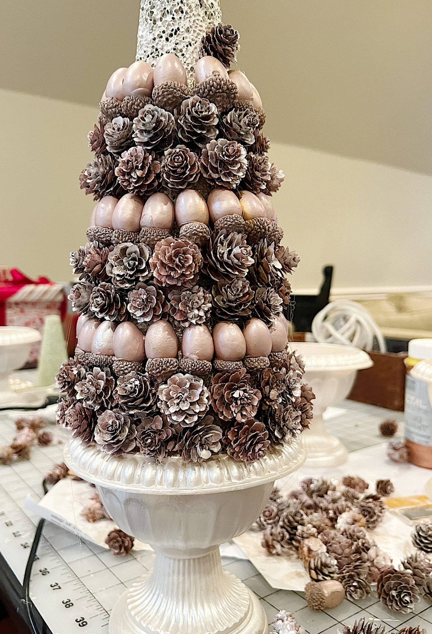 A DIY to make mini Christmas trees decorated with pinecones and acorns.