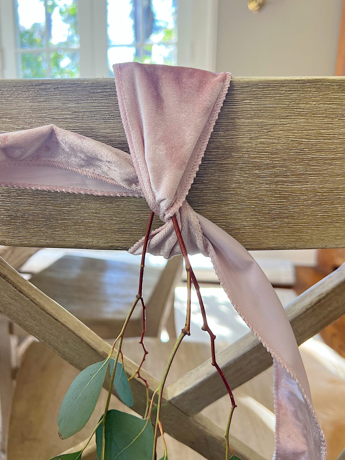 Tying a bow on the back of a dining room chair.
