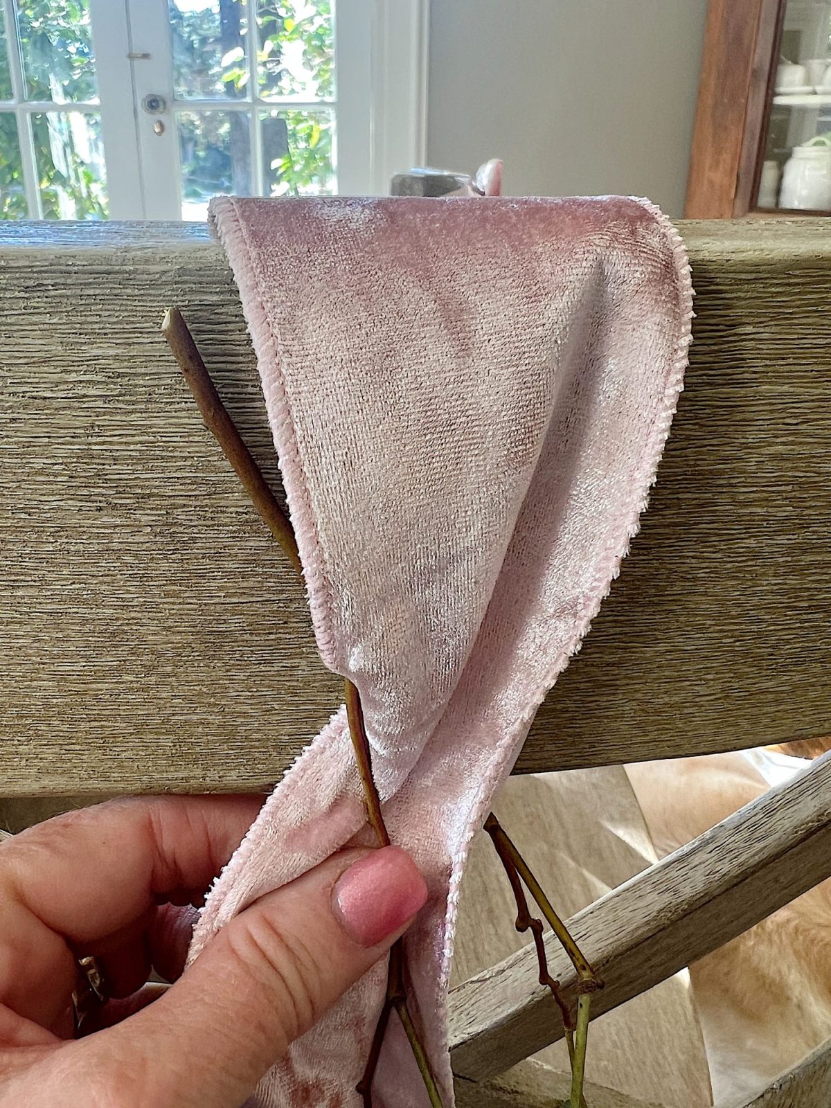 Tying a bow on the back of a dining room chair.