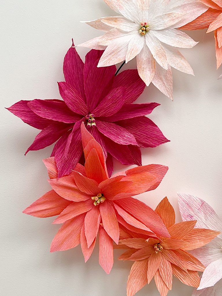 How to make a stunning poinsettia Christmas wreath using crepe paper, wire, and pan pastels.
