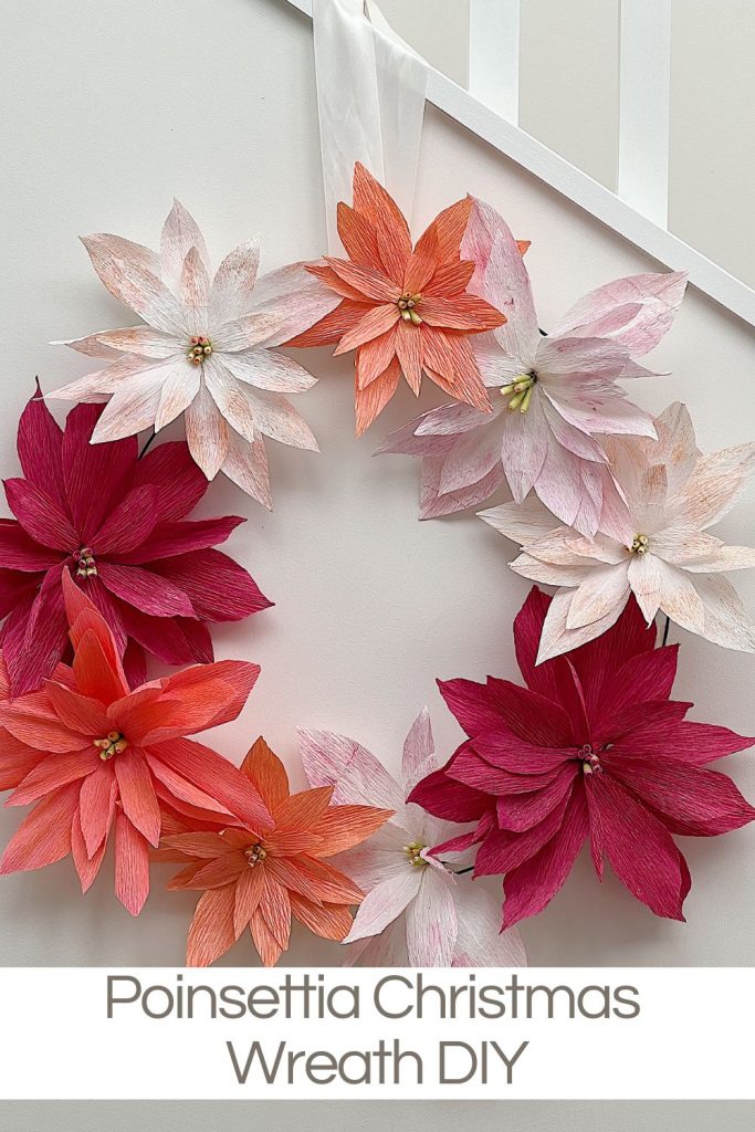 A hanging and stunning poinsettia Christmas wreath handmade using crepe paper, wire, and pan pastels.