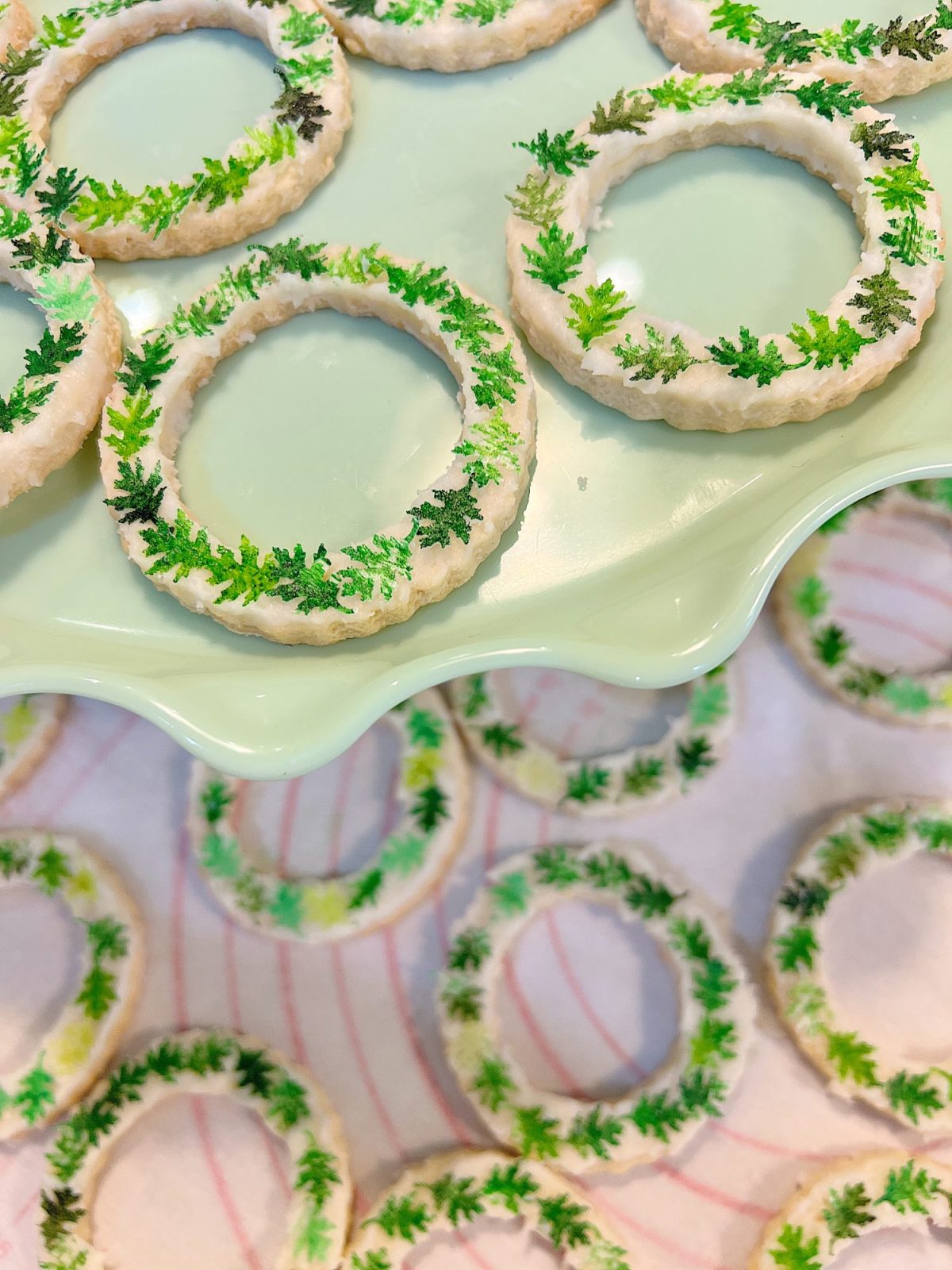 Homemade sugar cookies with buttercream frosting decorated with wafer paper wreaths.