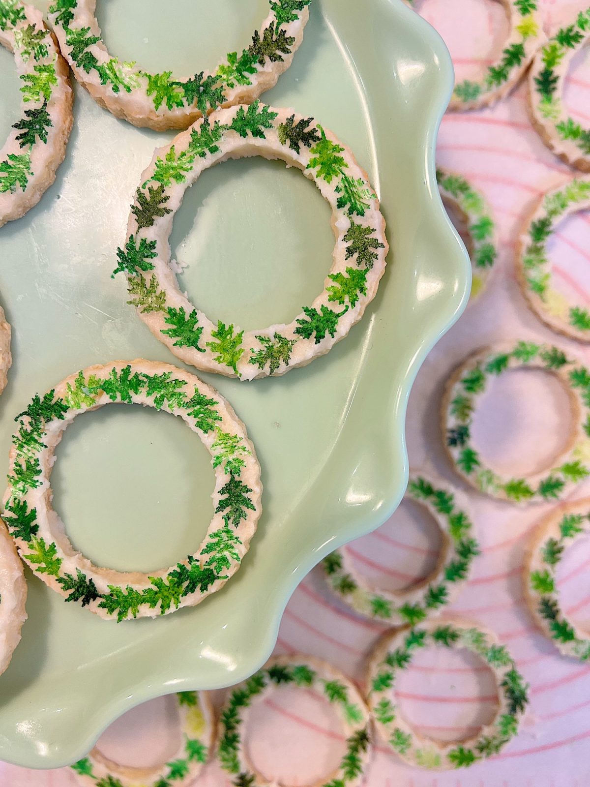 Homemade sugar cookies with buttercream frosting decorated with wafer paper wreaths.