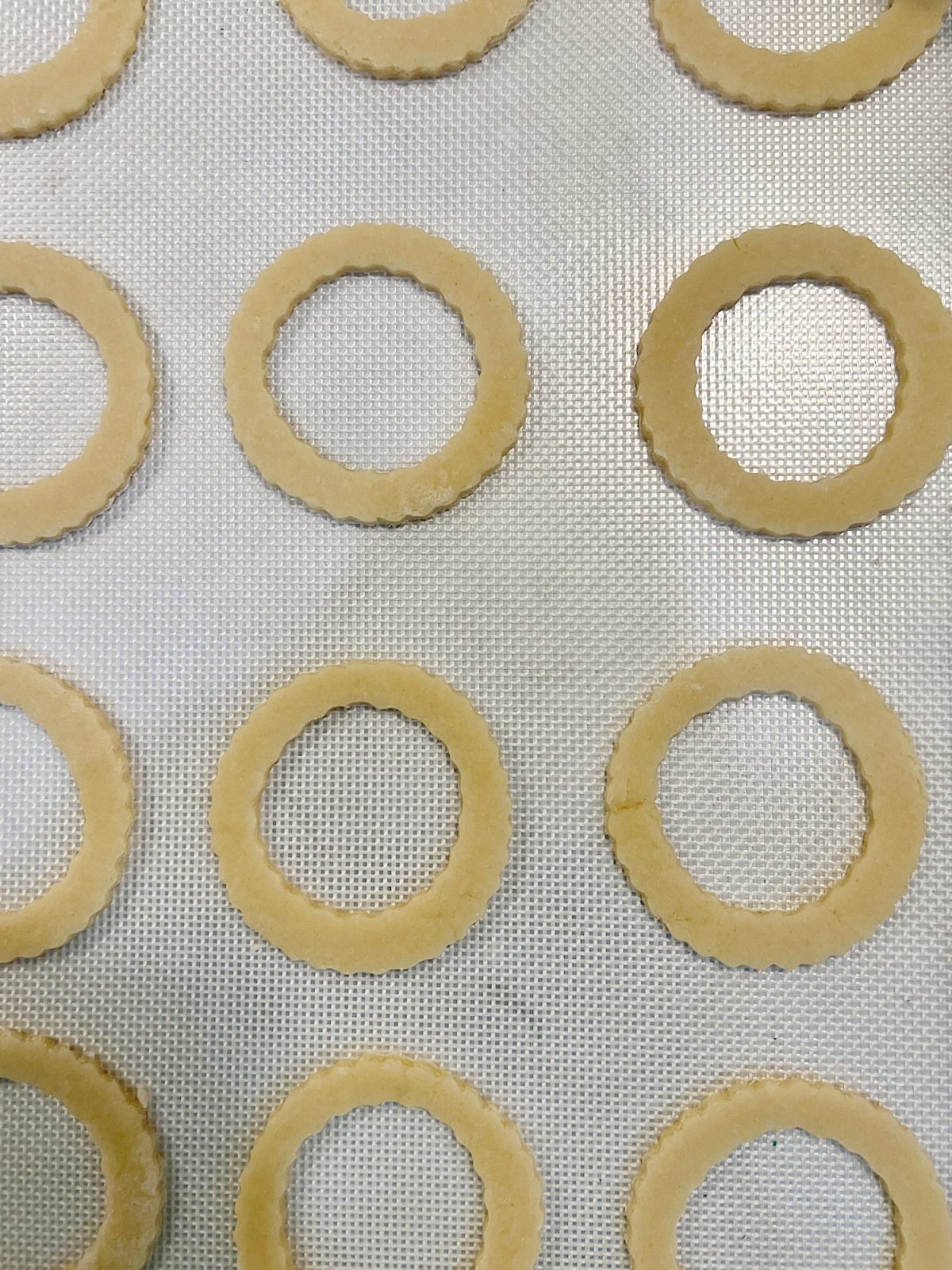 Homemade sugar cookies with buttercream frosting decorated with wafer paper wreaths.