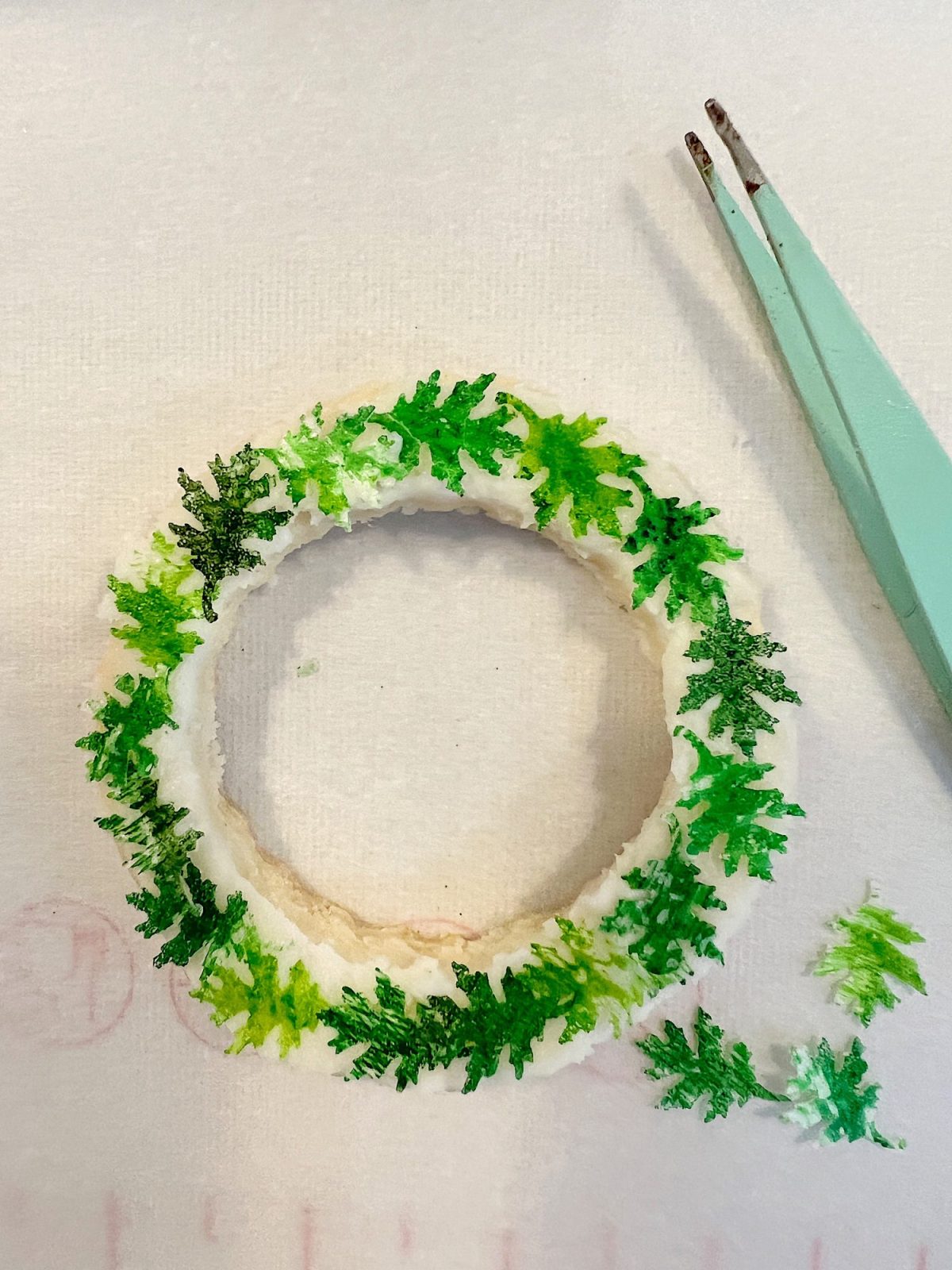 Homemade sugar cookies with buttercream frosting decorated with wafer paper wreaths.
